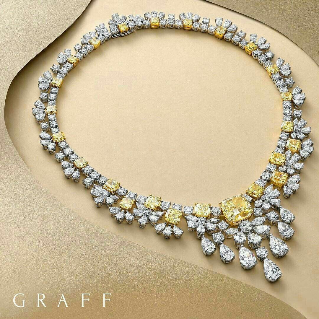 A curved necklace of pale and yellow-toned floral clusters with a larger center drop.