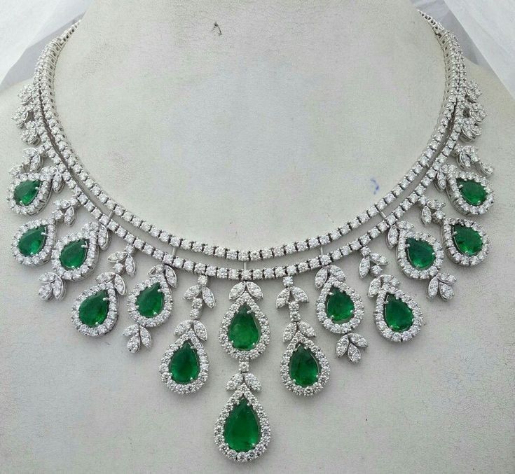 A curved necklace with evenly spaced green-toned teardrop accents.