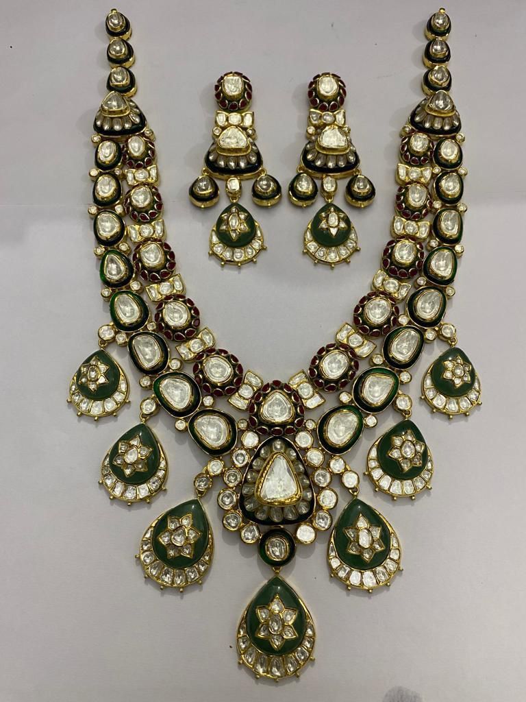 A necklace with green-toned teardrop details, shown with matching earrings.