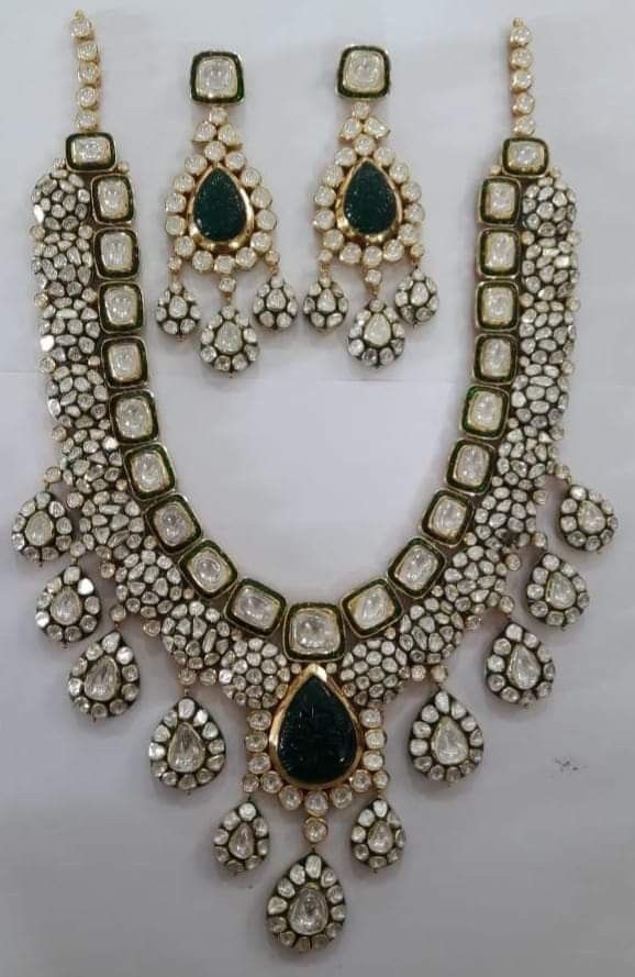 A pale necklace with a green-toned oval center and matching drop earrings.