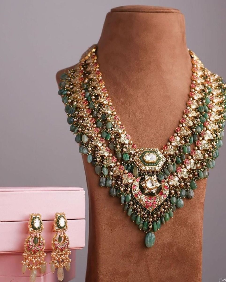 A layered necklace with green and rose-toned accents, shown with matching earrings.