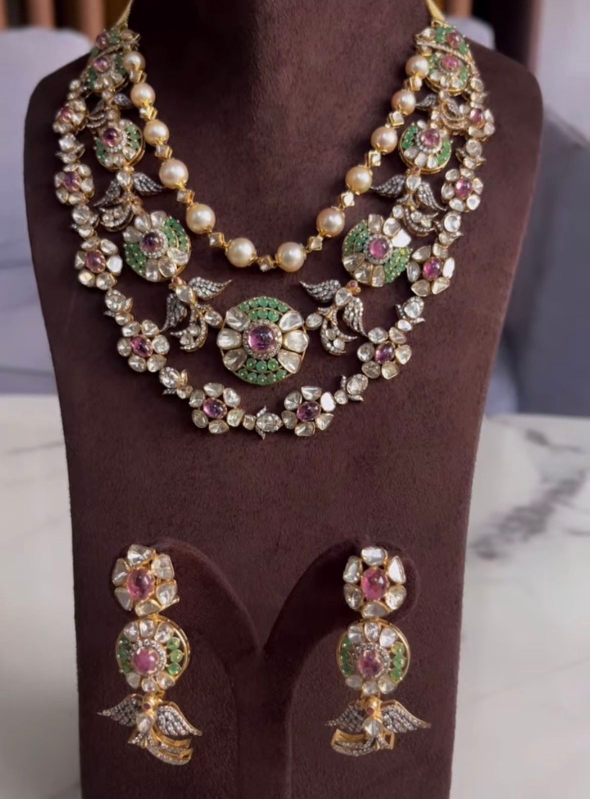 A necklace with floral cluster details, shown with matching earrings.