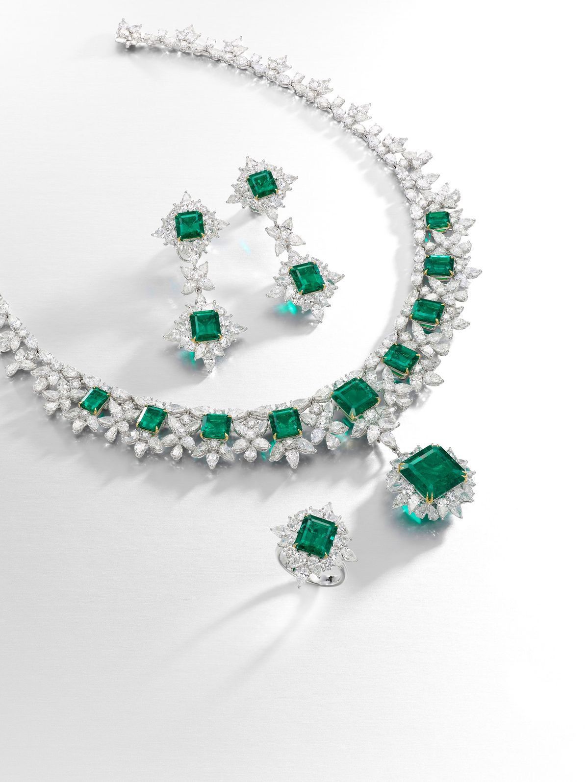 A necklace with green-toned square details, shown with matching earrings and other pieces.