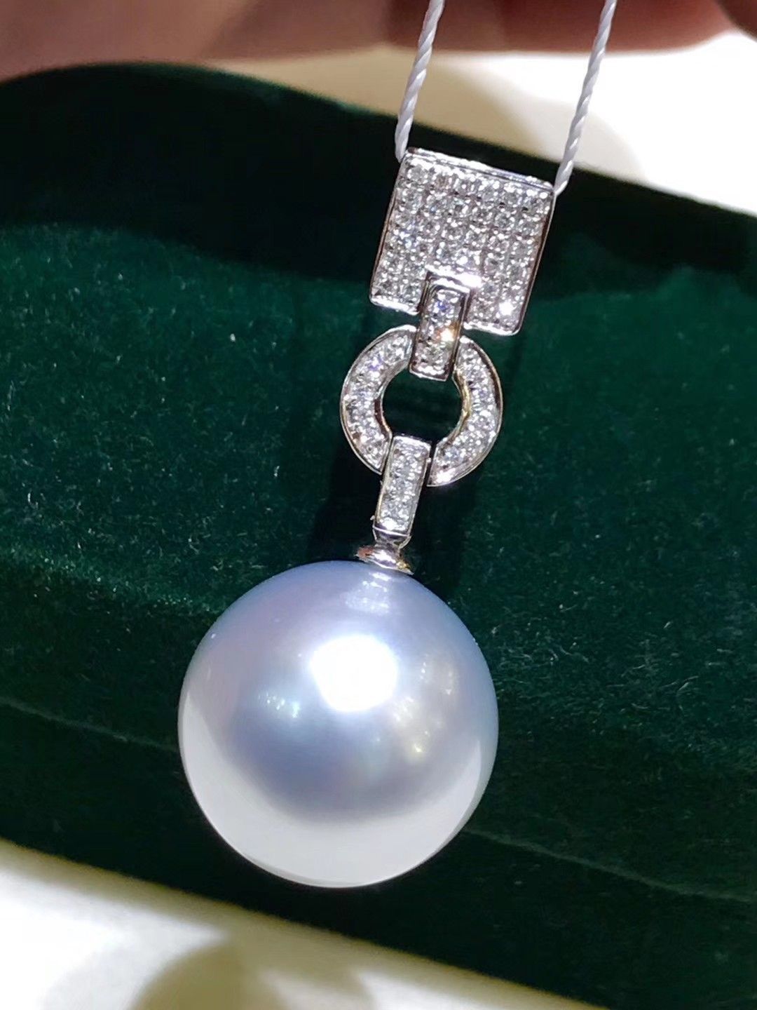 A necklace with a pale round pendant and a small blue-toned accent.