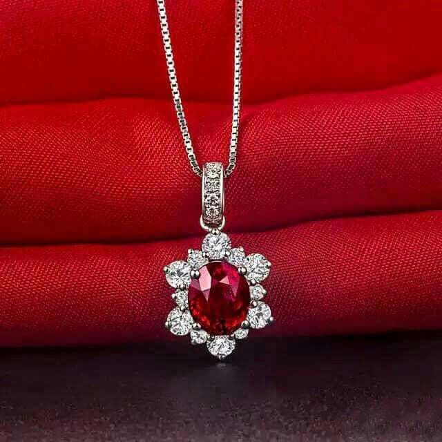 A fine necklace with a red-toned center pendant framed by pale details.