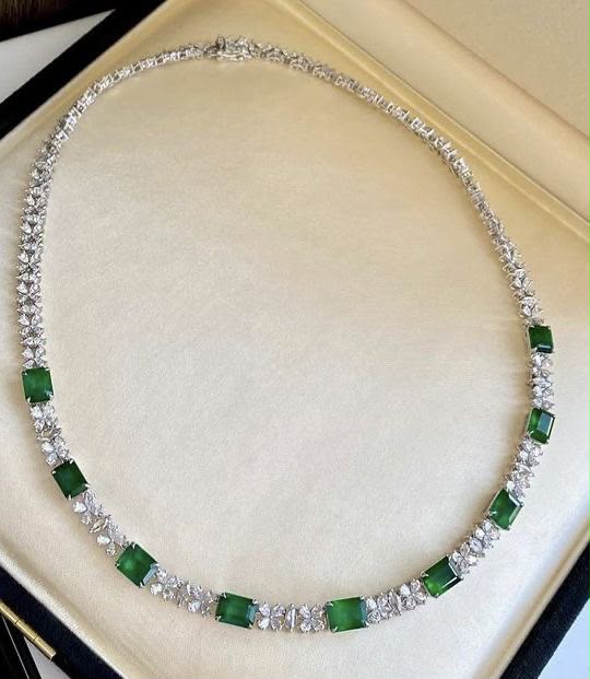 A fine necklace with spaced green-toned square accents.