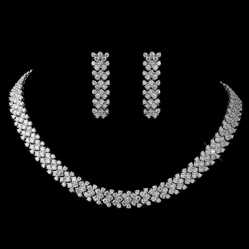 A broad pale necklace with two matching long drop earrings.