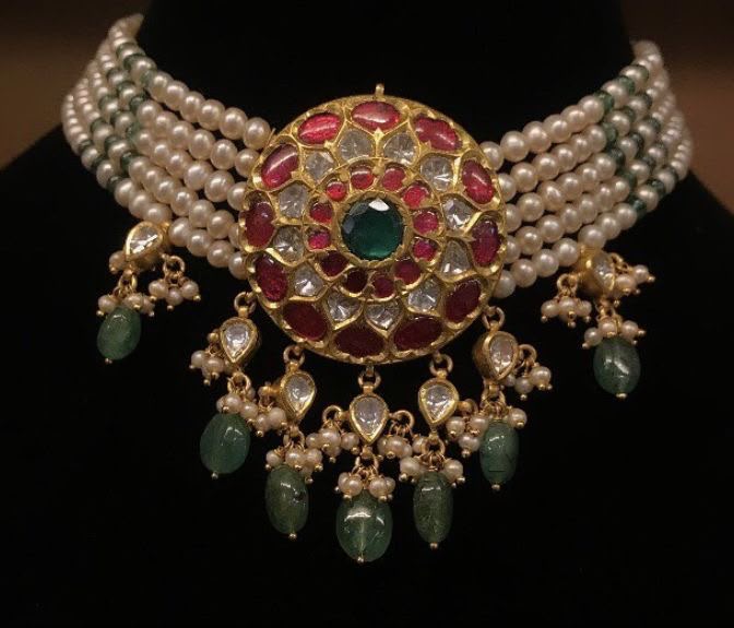 A broad pale choker with red and green center details and matching drops.