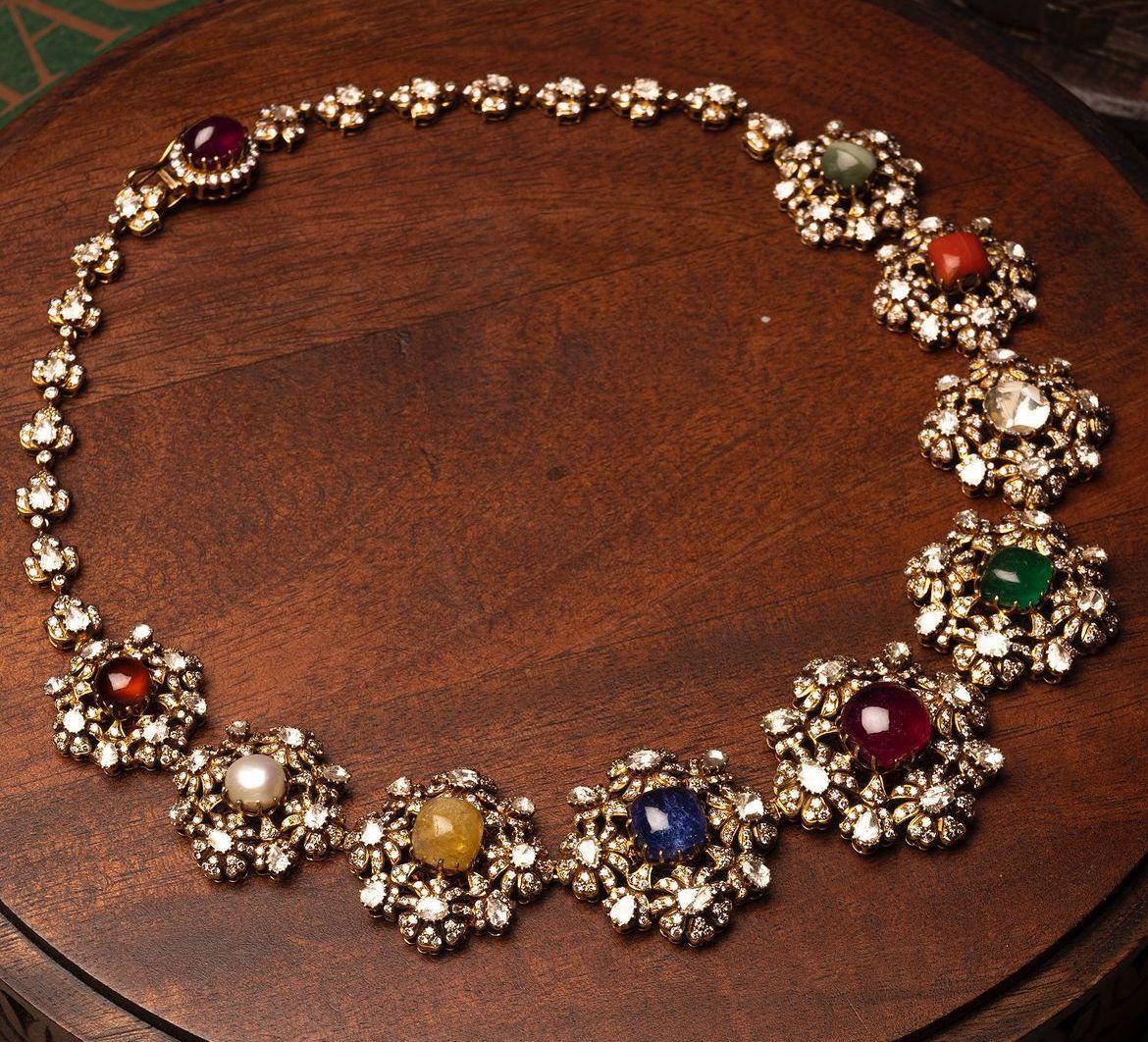 a floral arrangement of bright details along a curved necklace