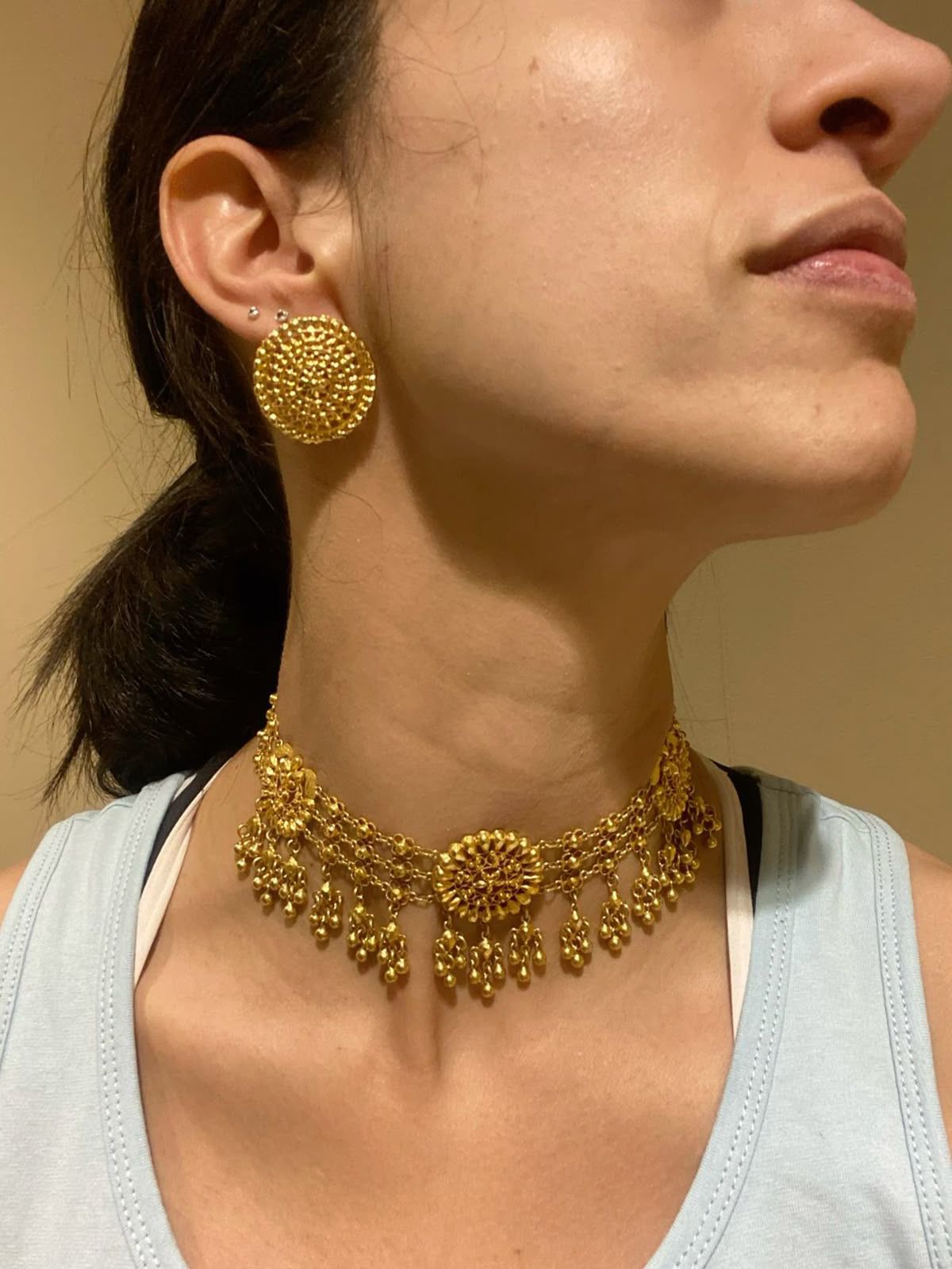 a close-fitting necklace shown alongside earrings