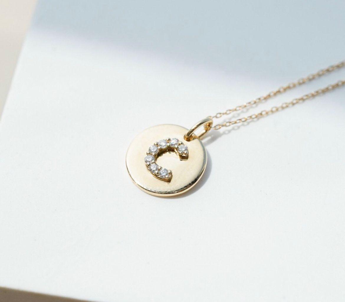 Gold pendant necklace with a small circular motif