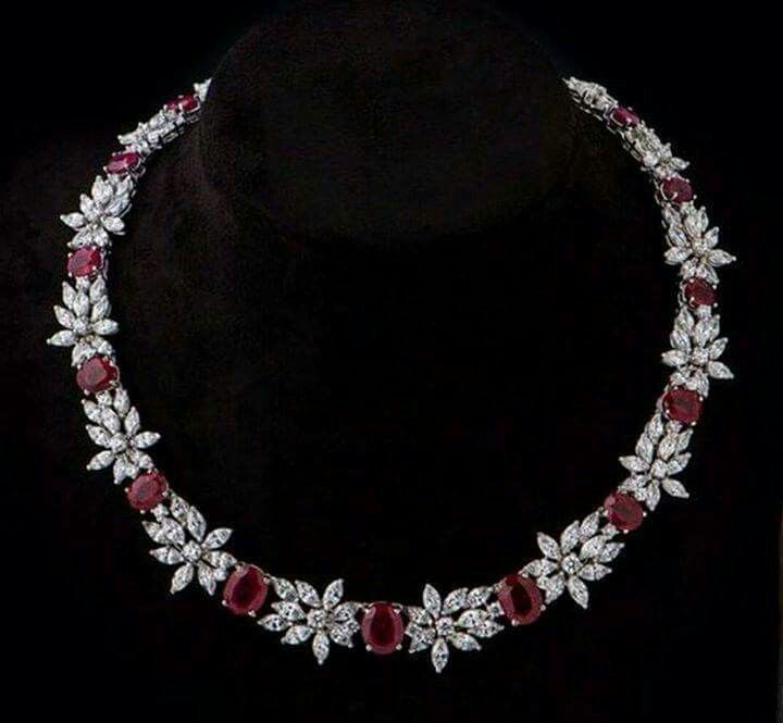 a curved necklace with red-toned and pale floral details