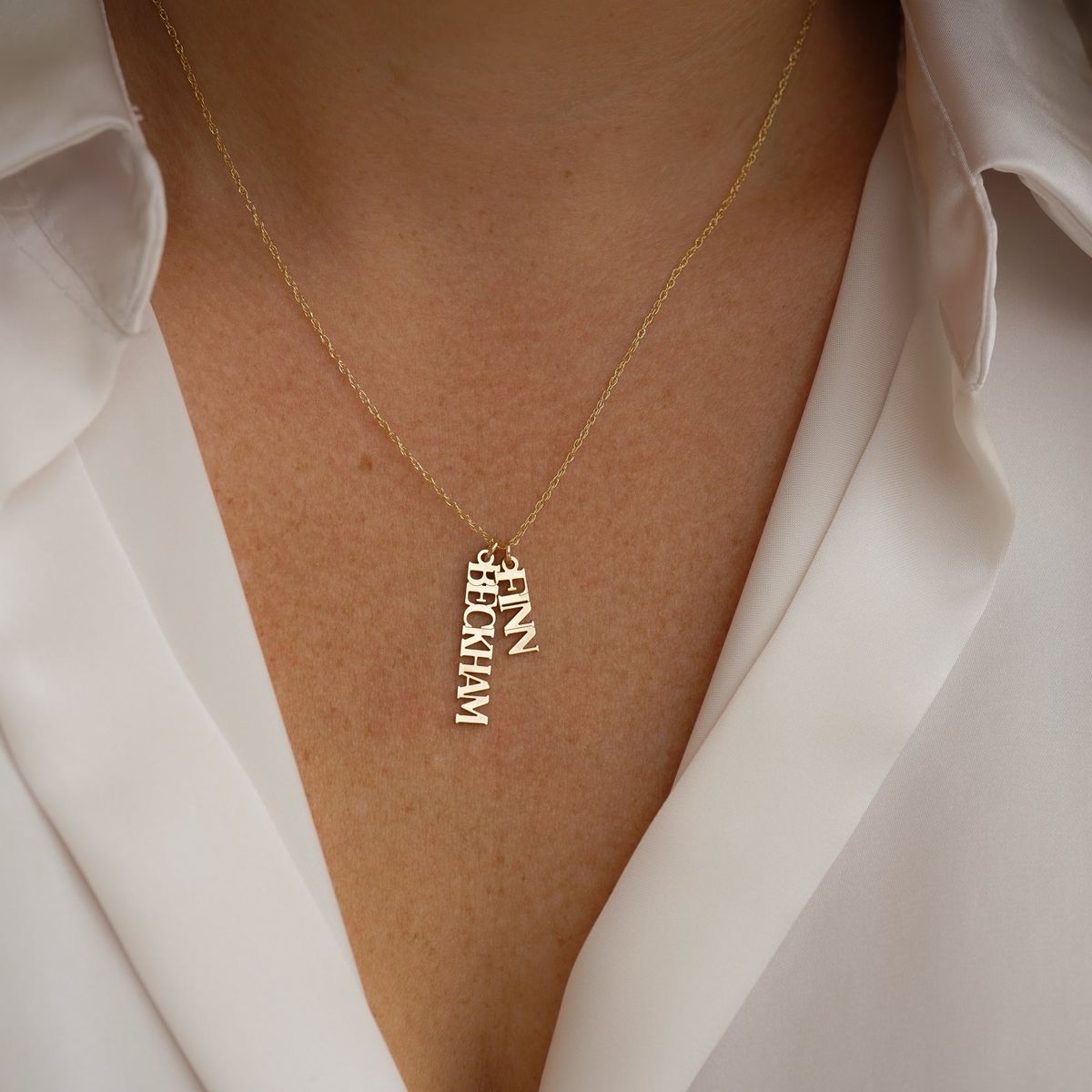 a vertical letter-shaped pendant on a fine chain
