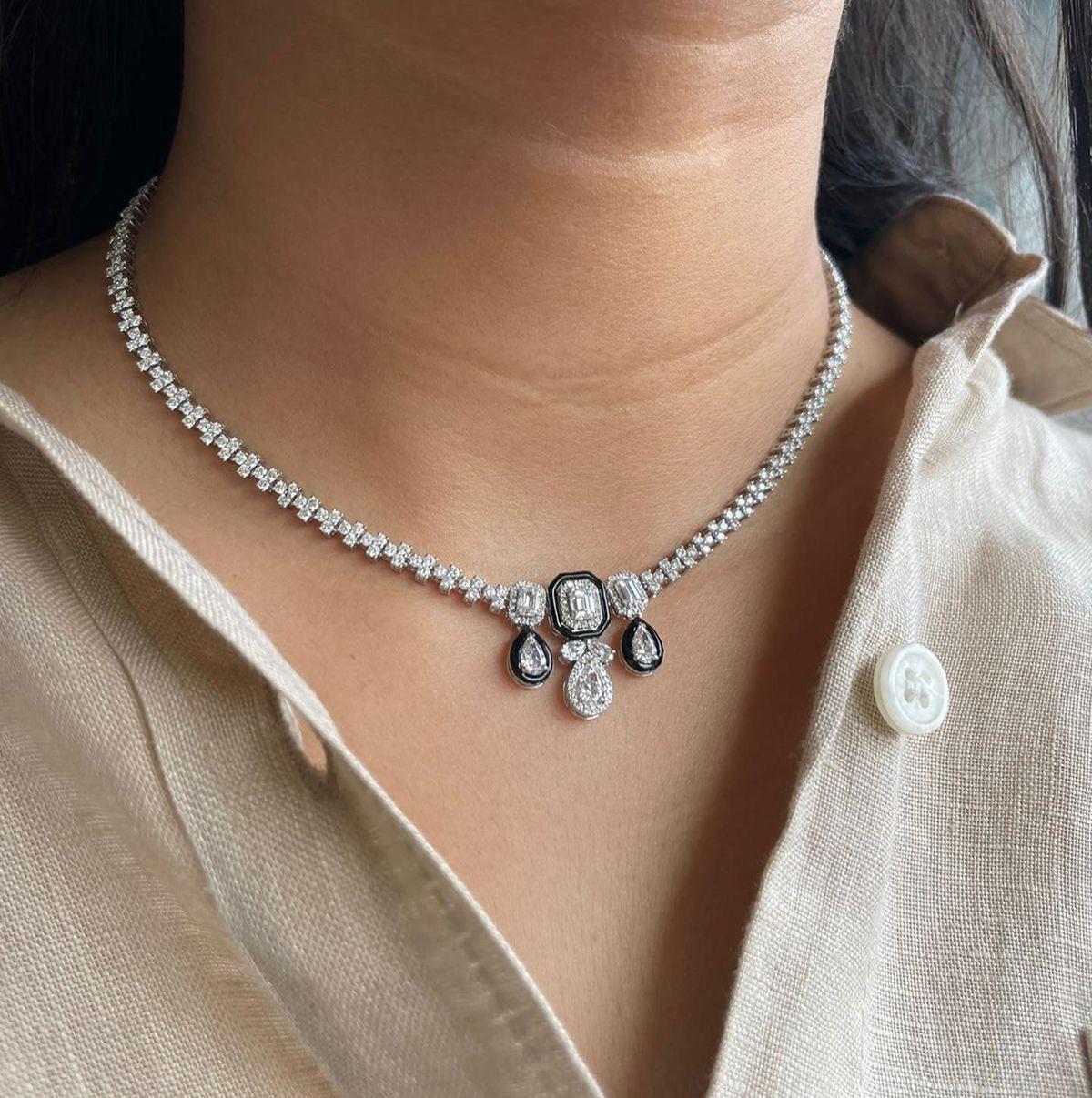 a curved necklace with repeated pale drop-shaped details