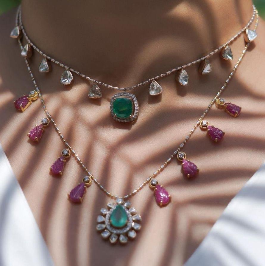 several necklace layers with a central green-toned pendant