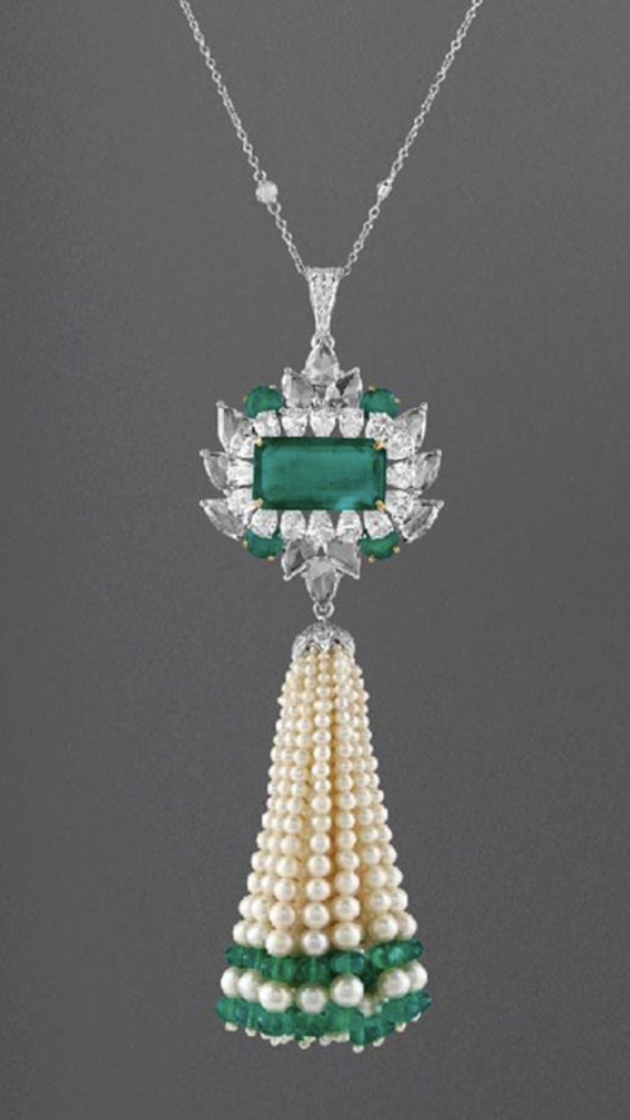 a centered green-toned detail with a long hanging drop