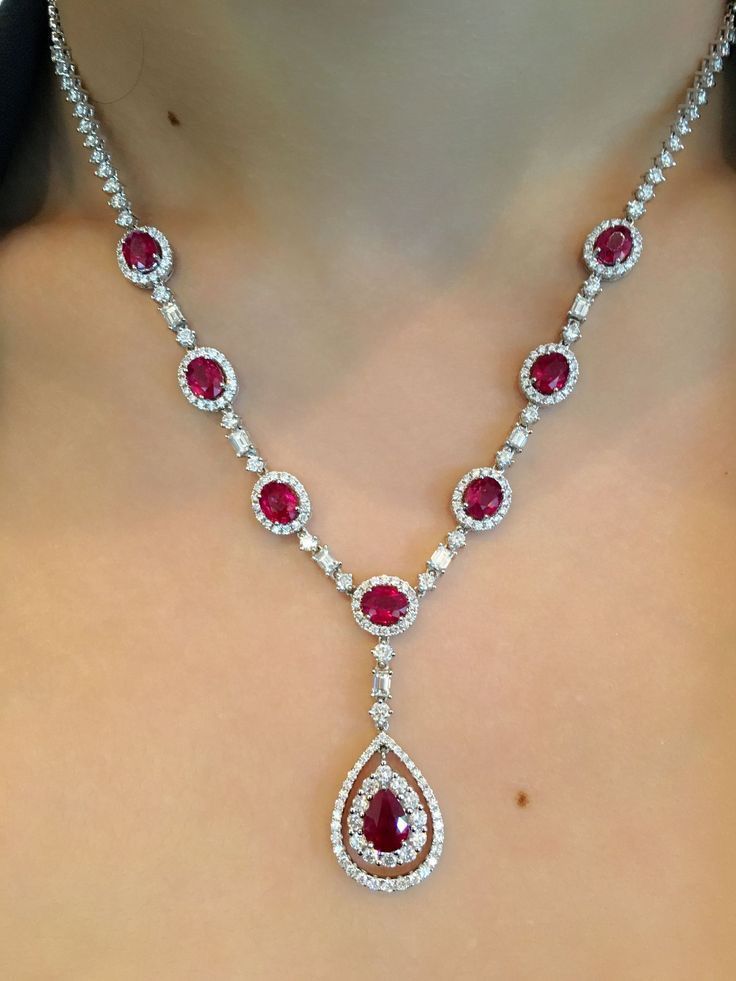 a necklace with red and pale accents and a central drop