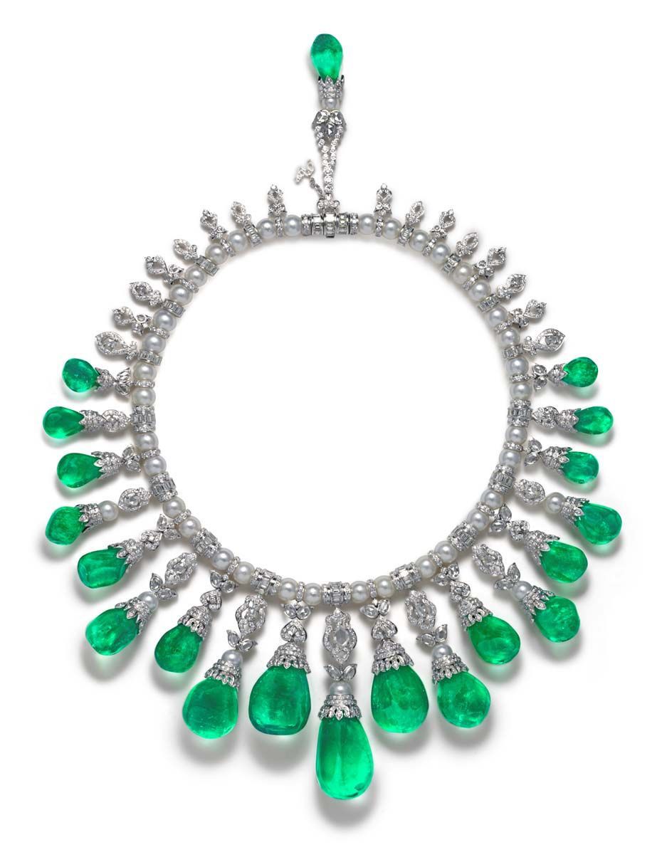 A circular necklace design with green-toned drops and a small top accent.