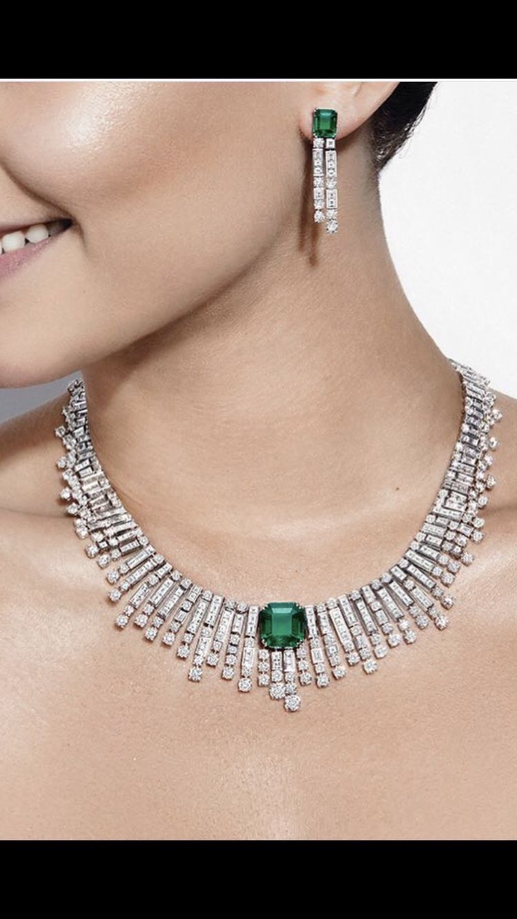 A necklace with a green-toned center detail, shown with matching earrings.
