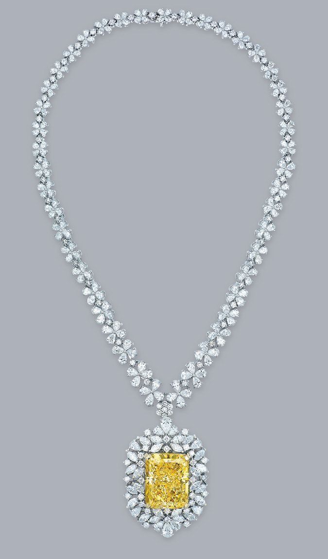 A fine necklace with a yellow-toned square center pendant framed by pale details.