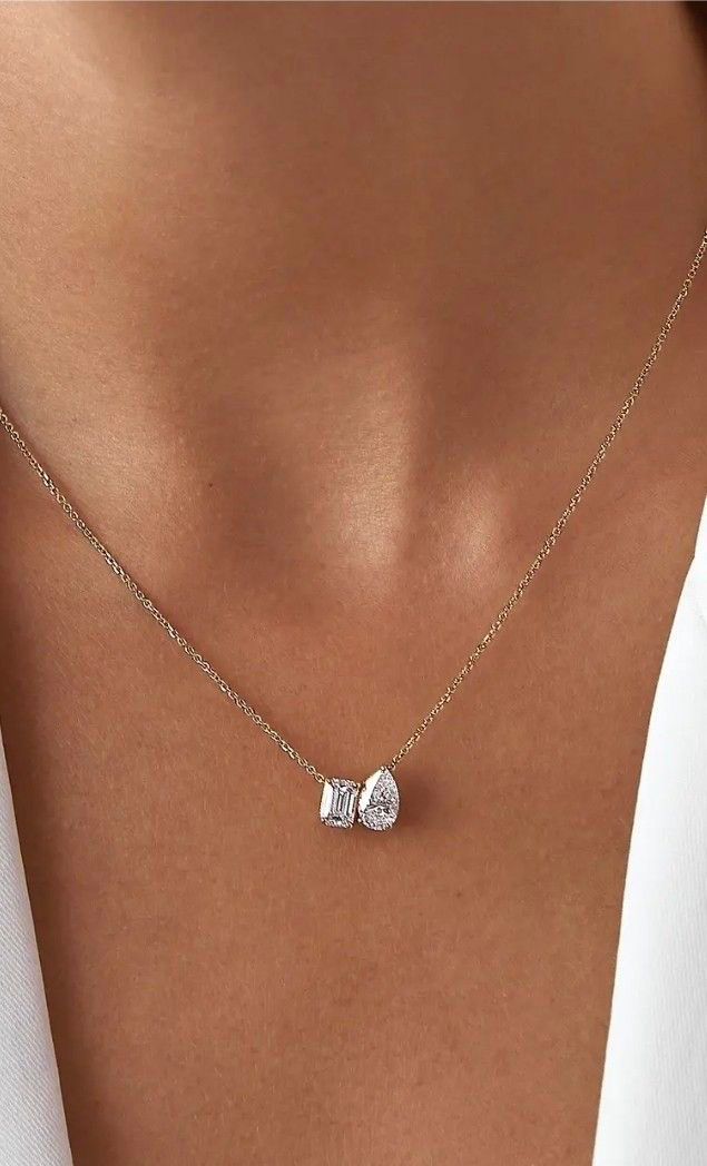A fine chain necklace with two small adjoining square pendant details.