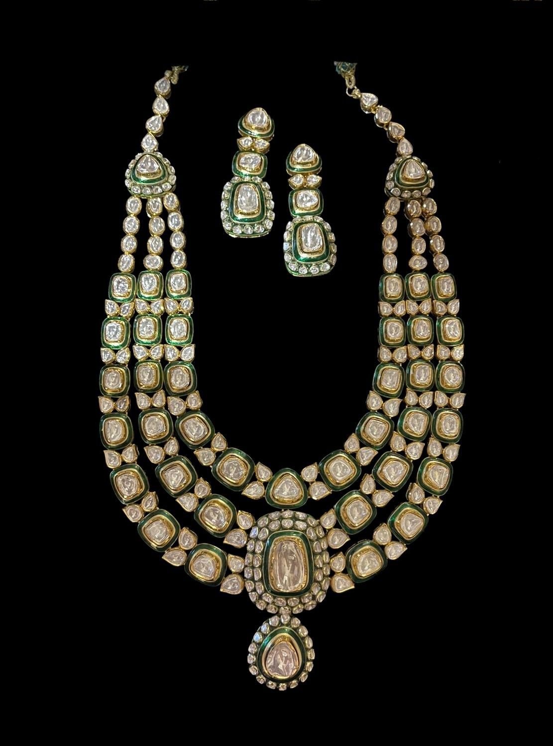 A pale floral necklace with green-toned center details, shown with matching pieces.