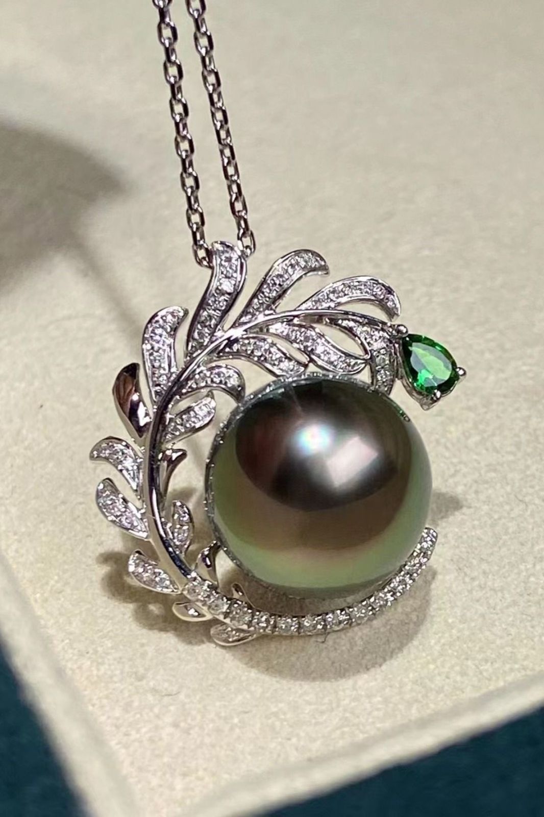 A pendant with a dark round center and a curved branch-like frame.