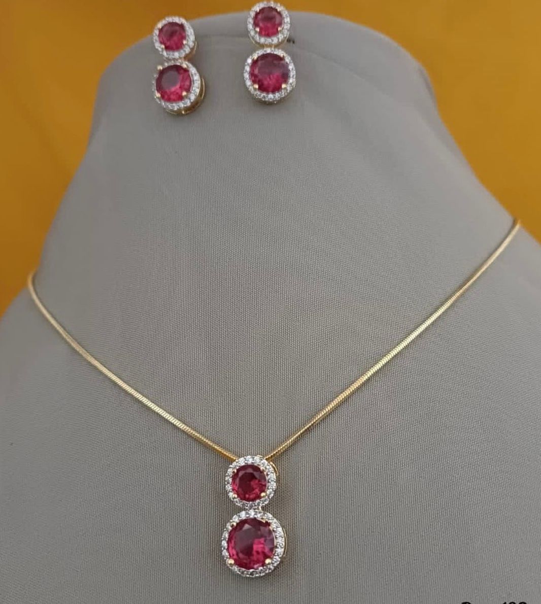 A fine necklace with red-toned oval details, shown with matching earrings.