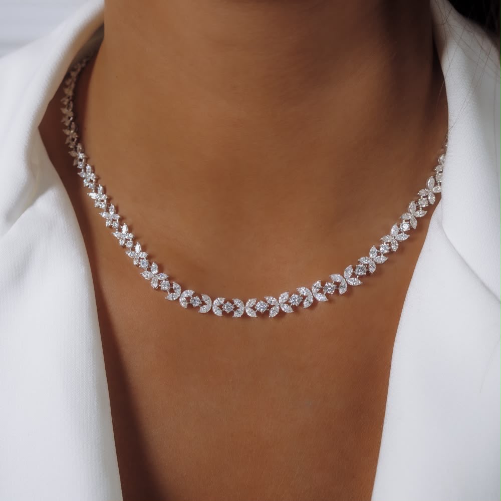 A short necklace with repeating pale floral-shaped details.