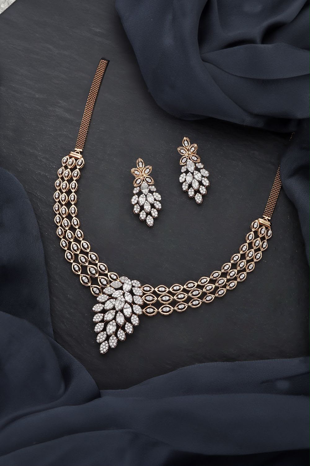 A necklace with geometric drop details, shown with matching earrings.