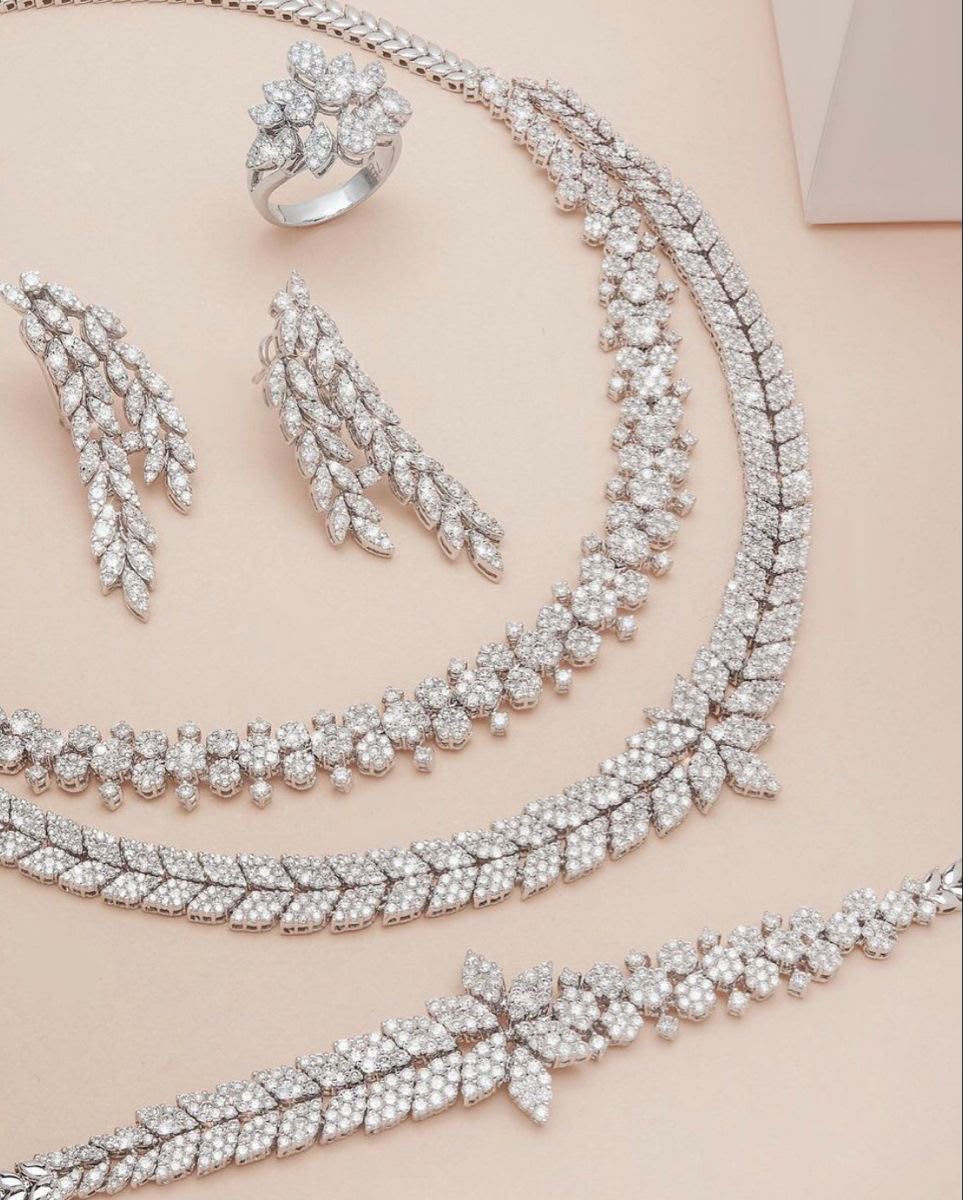 A coordinated display of necklace, earrings, and bracelet with pale details.