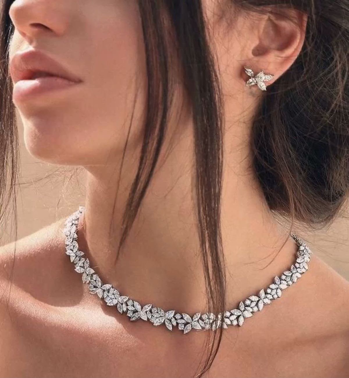 A necklace with repeating pale petal details, shown with matching earrings.