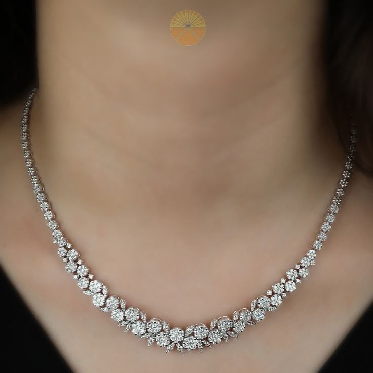 A curved necklace with closely spaced pale floral-shaped details.