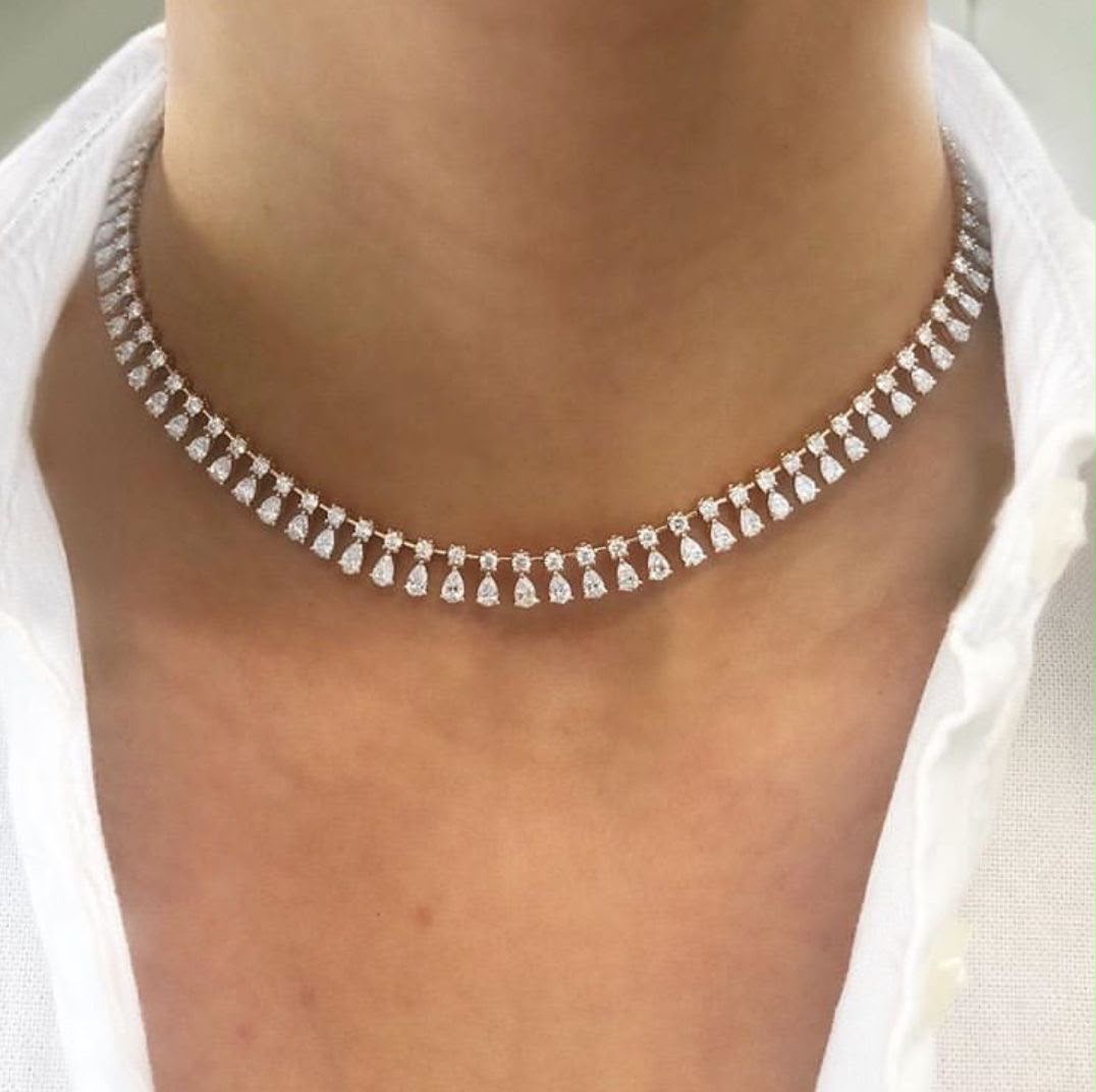 A short necklace with a repeating row of pale geometric drops.