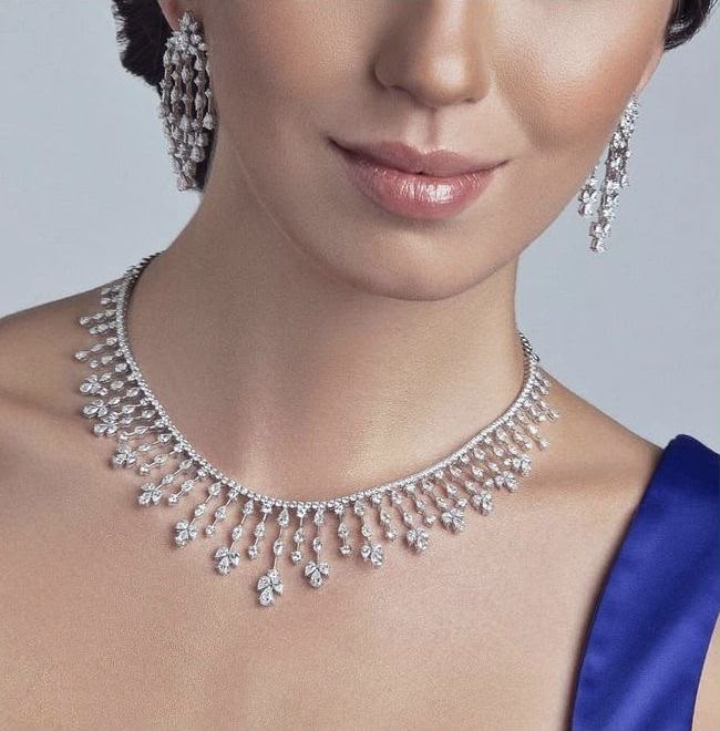 A necklace with pale cluster drops, shown with matching earrings.