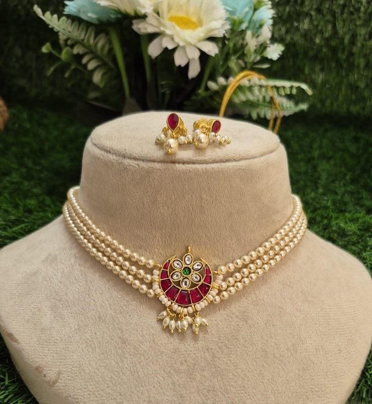 A multirow red-toned choker with green center details and matching earrings.