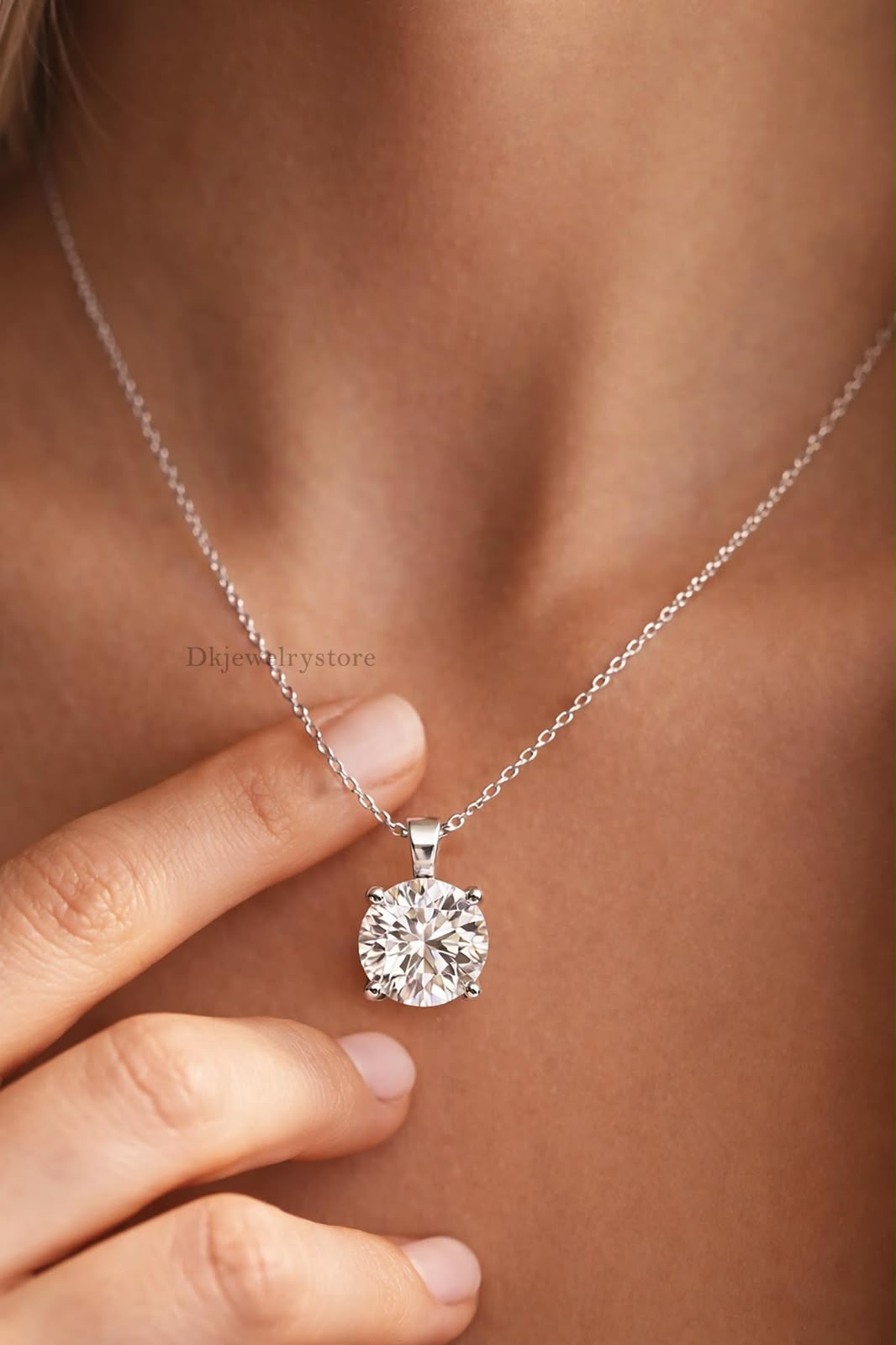 A fine chain necklace with a small round pale pendant.