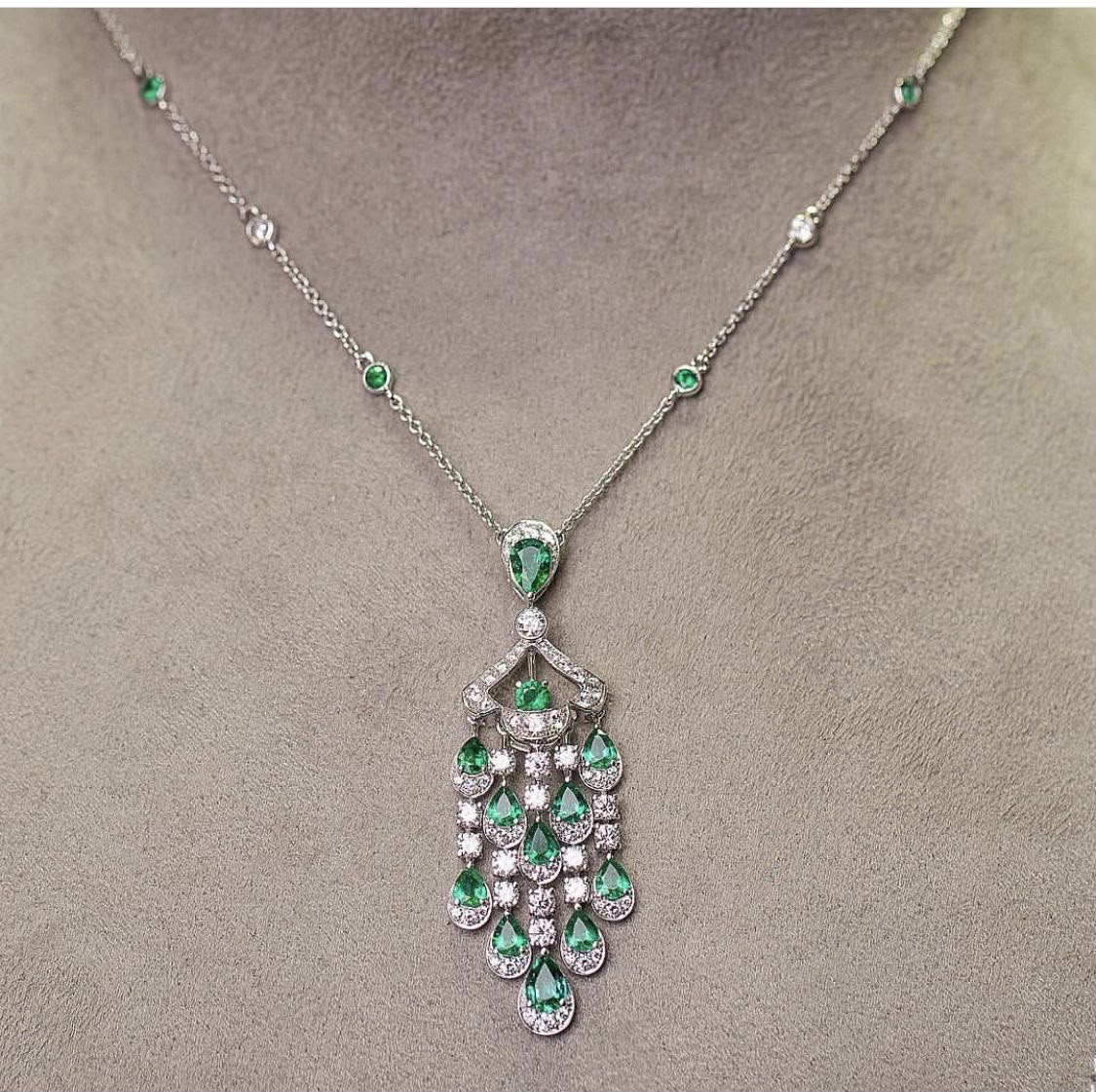 A fine necklace with green-toned accents and a long scroll-shaped pendant.