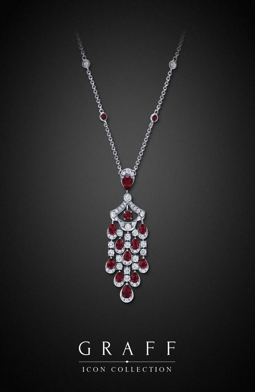 A fine necklace with a long red-toned pendant formed from linked drops.