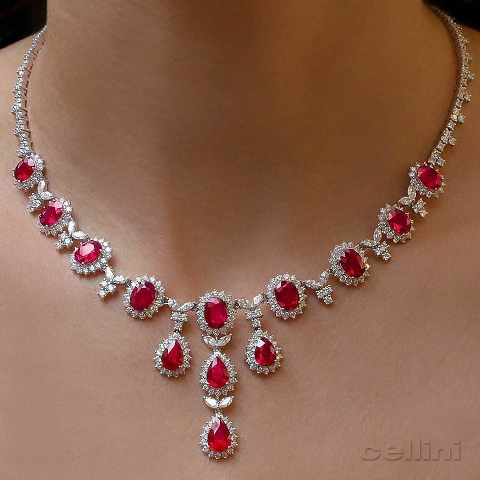 a curved necklace with repeated red-toned center details