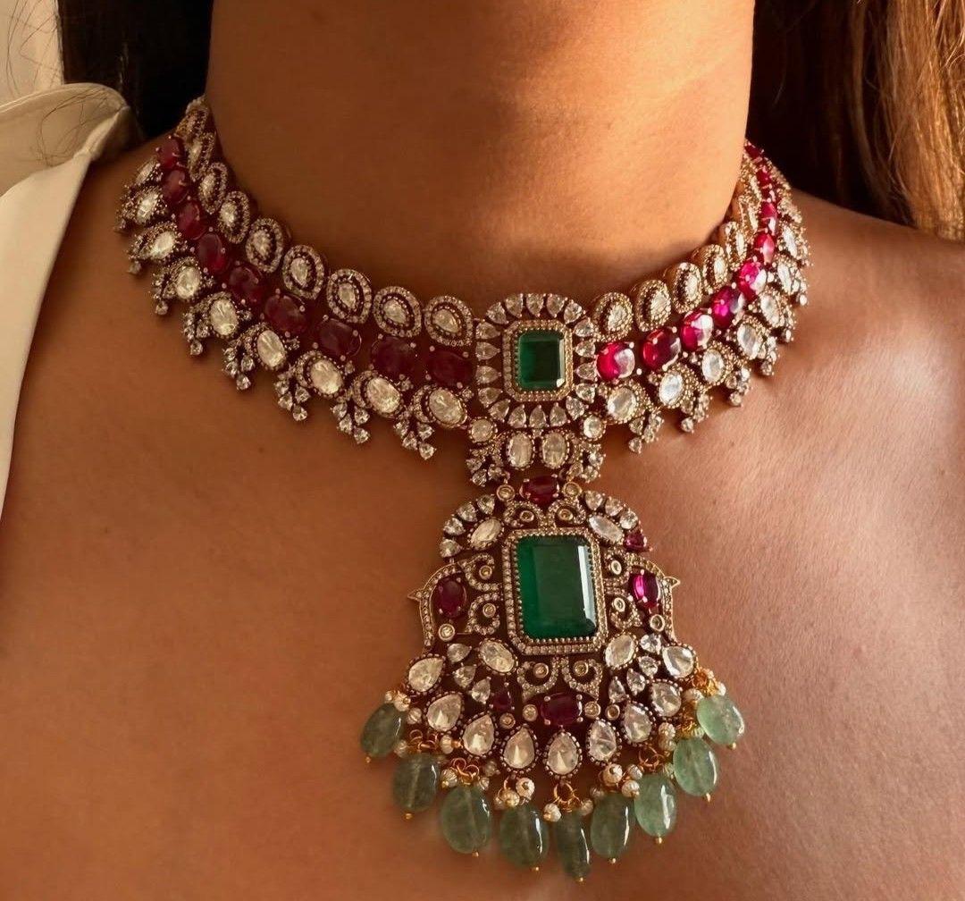 a close-set necklace with a green-toned center and hanging details