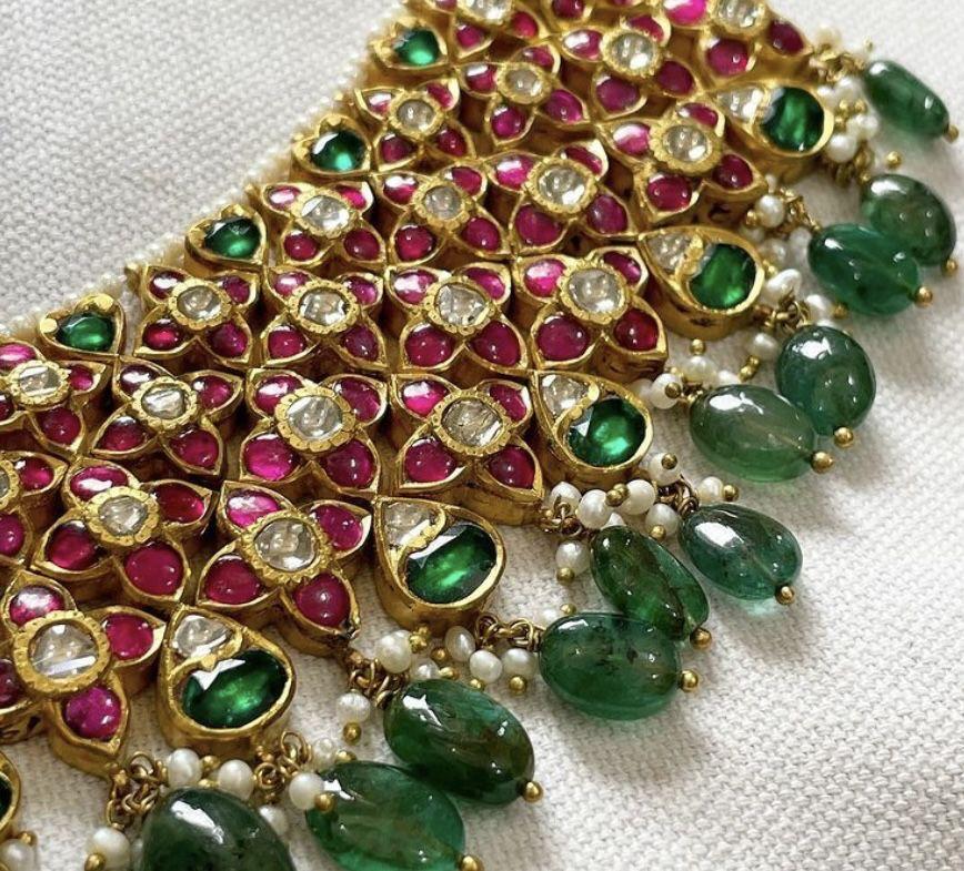 a necklace with green and pink-toned accents
