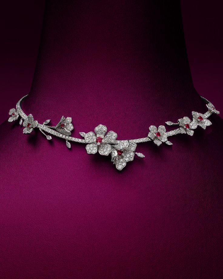 a curved necklace with repeating flower-like details