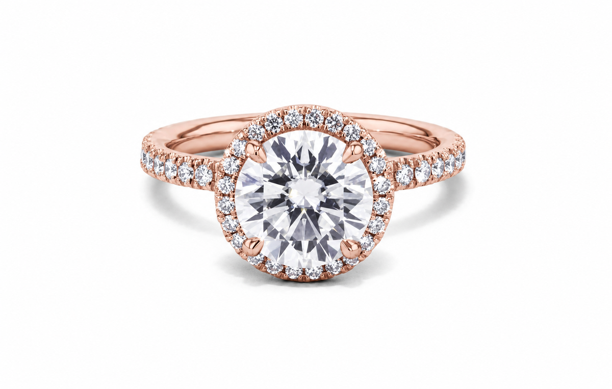 A round clear centre is encircled by a delicate halo on a rose-coloured, stone-lined band.