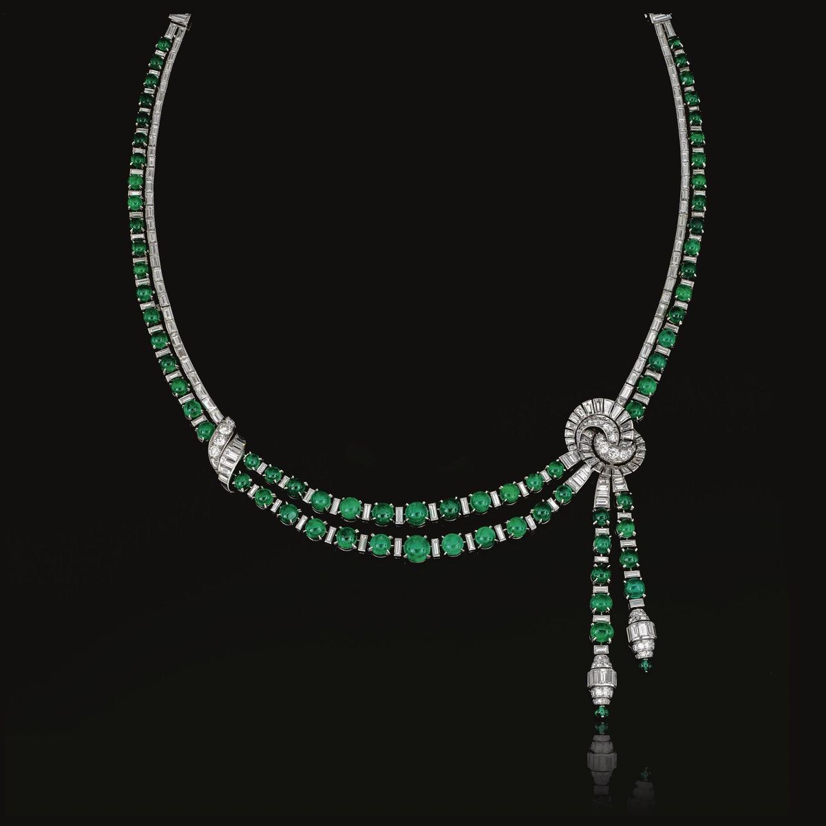 a curved necklace with repeated green-toned framed details