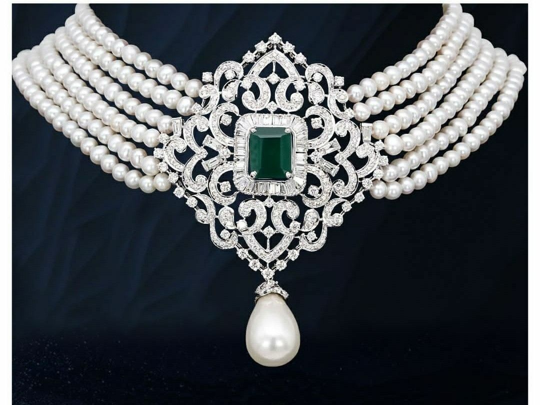 Necklace featuring a central green-toned detail framed by rows of pale accents
