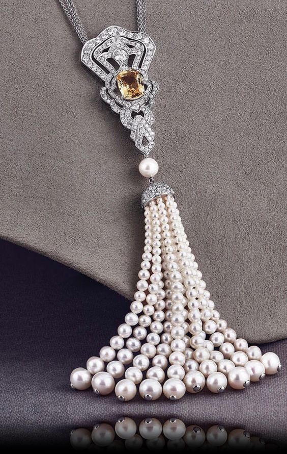 an ornate pendant with a long beaded drop