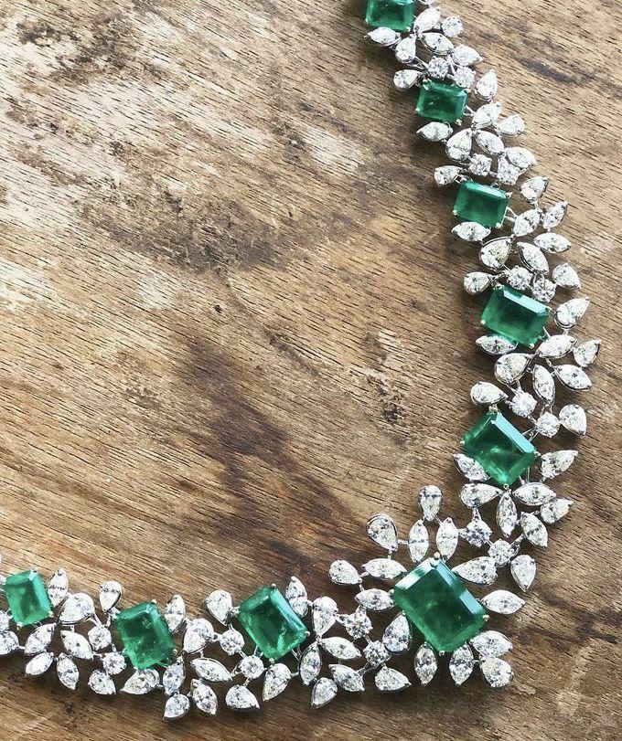 a curved necklace with green-toned and bright drop details