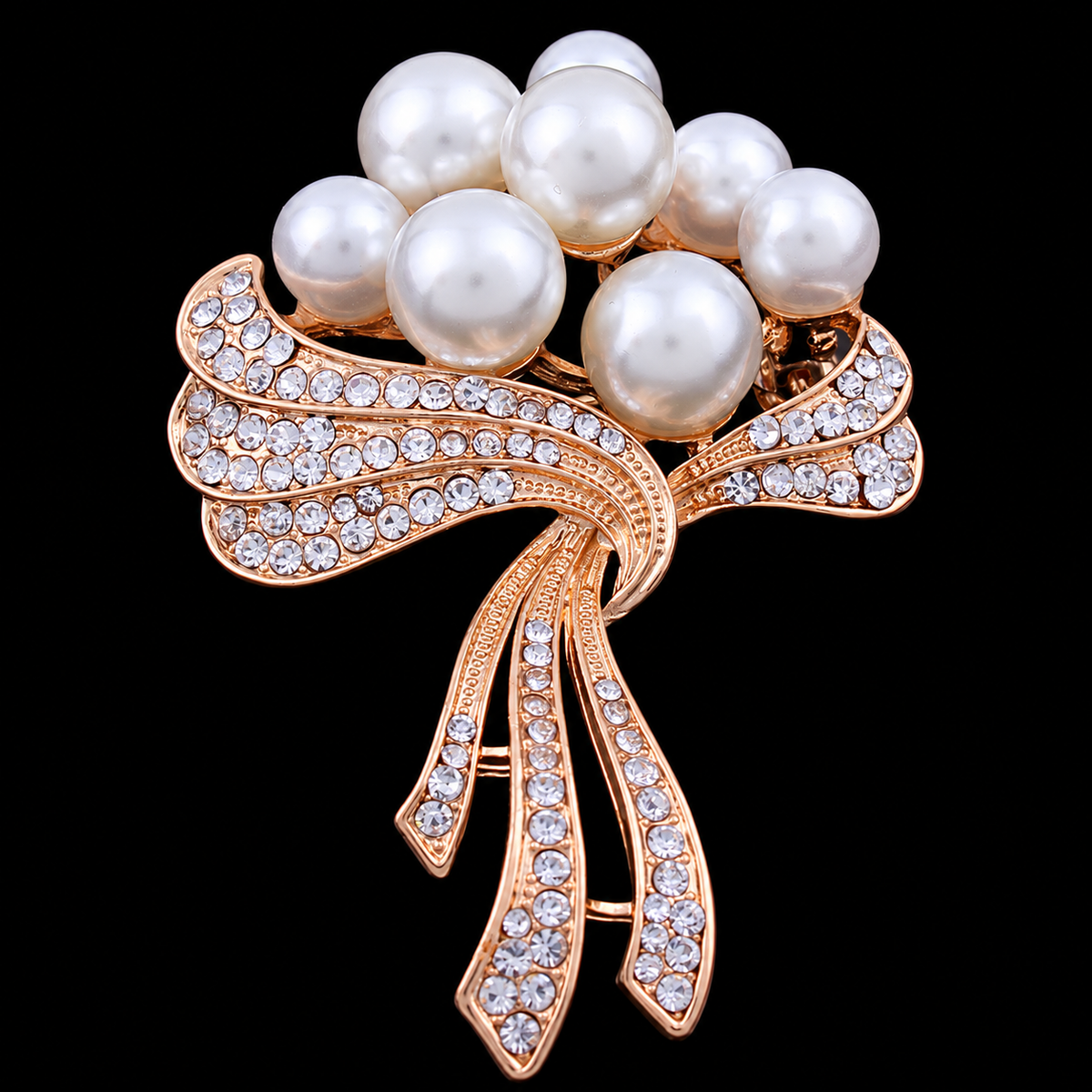 A cluster of pale round beads is gathered by rose-coloured sparkling ribbons with flowing ends.