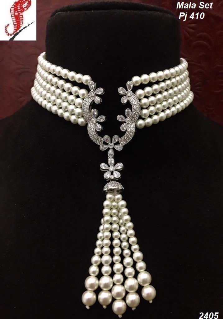 a layered necklace with a long rounded drop